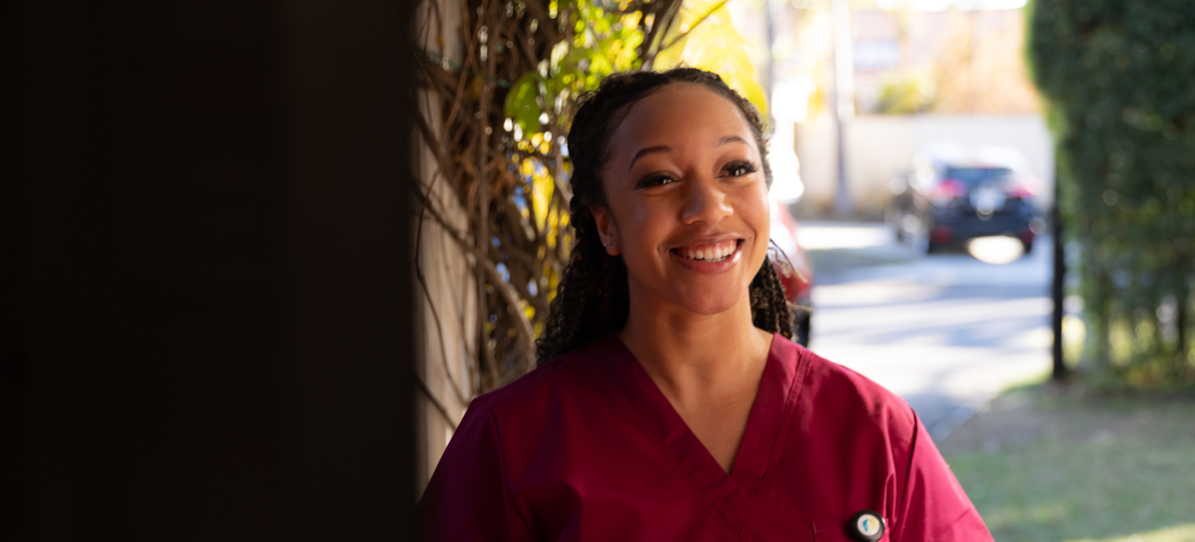 Signify Health female provider holding badge and smiling