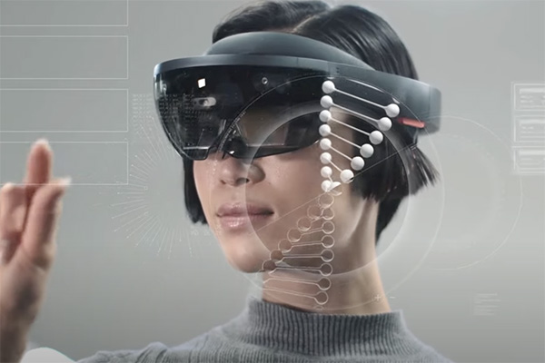 A person wearing augmented reality glasses interacts with a virtual display. A digital representation of a DNA strand floats in front of them. The background is filled with translucent interfaces and data visuals. The person extends their hand towards the display.