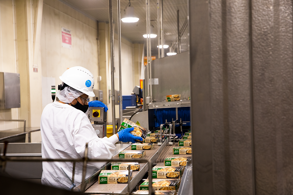 A team member looks at a Marie Callender's box on the line