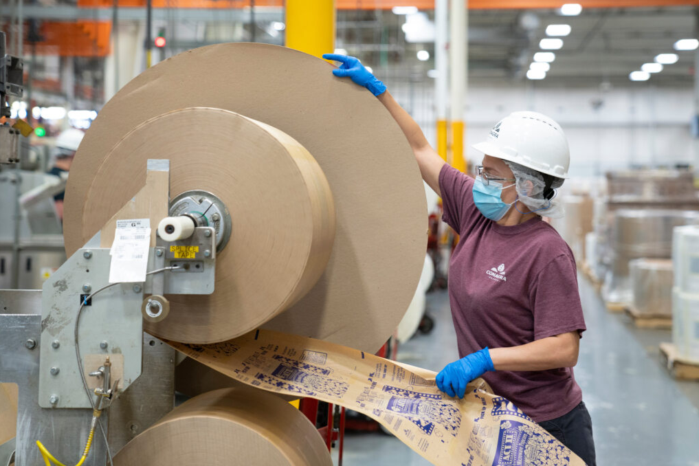 An employee works with ACT II packaging on a large roll