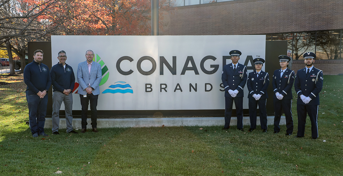 Veterans pose in front of the Conagra Brands sign in Omaha