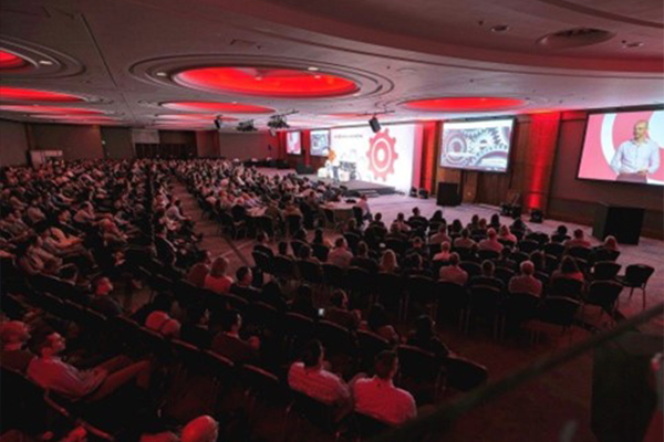 an aerial view of a person presenting at a large conference hall