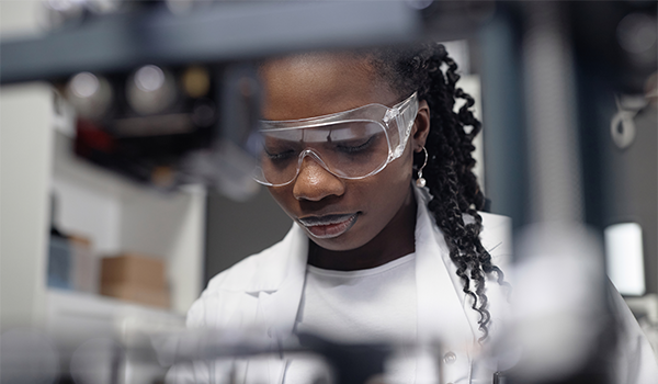 a female scientist wearing safety glasses works in a lab