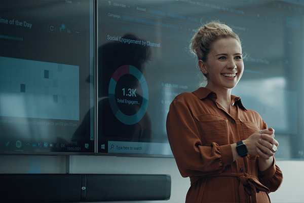 a woman standing in front of screens in a conference room