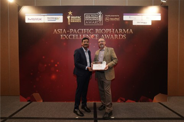 two men on stage behind a banner for the Asia-Pacific Biopharma Excellence Awards