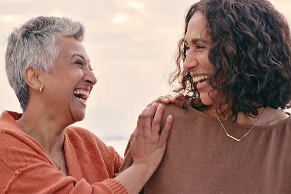 two women conversing and laughing together