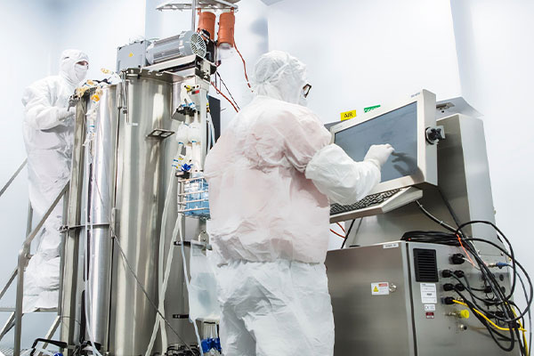 workers in full protective gear working on a large machine