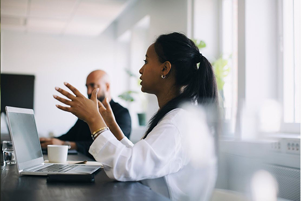 woman sitting in a conference room in front of her computer in conversation