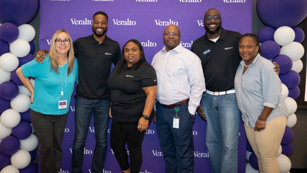 Members of the Black Engagement Network smiling against a purple Veralto background