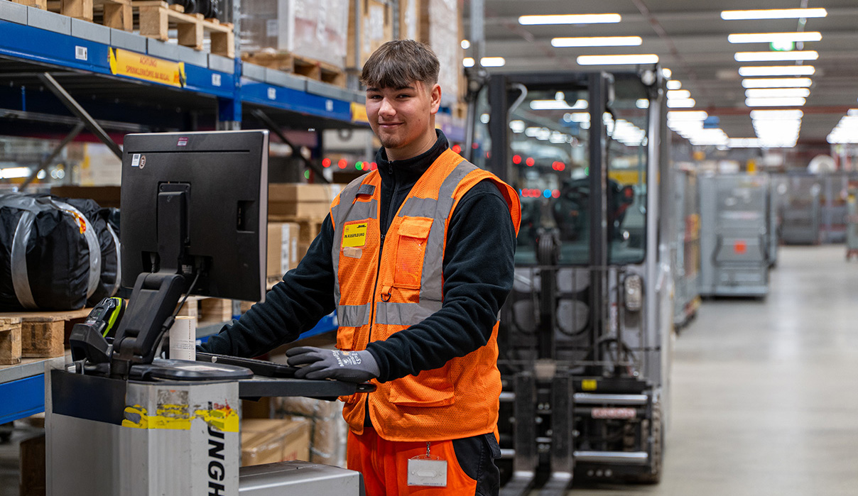 Fachkraft für Lagerlogistik am Computer in der Sortierhalle