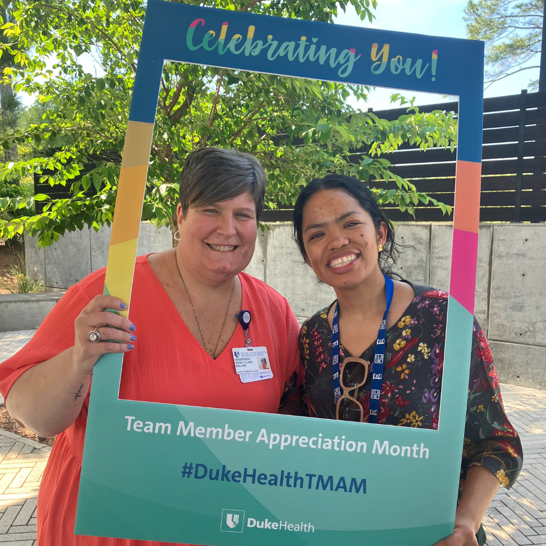 Team members smile with photo props during appreciation event.