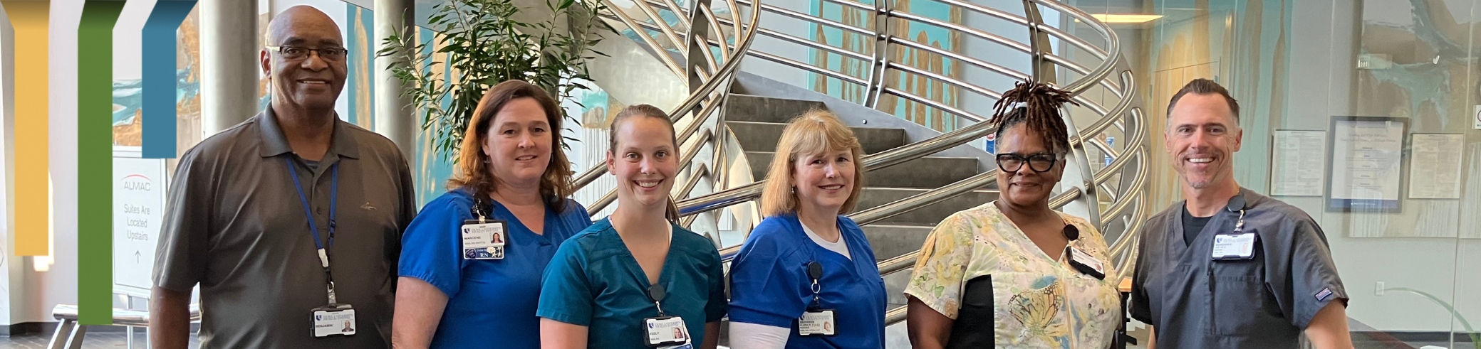 Duke HomeCare & Hospice team members smile in scrubs in hallway.