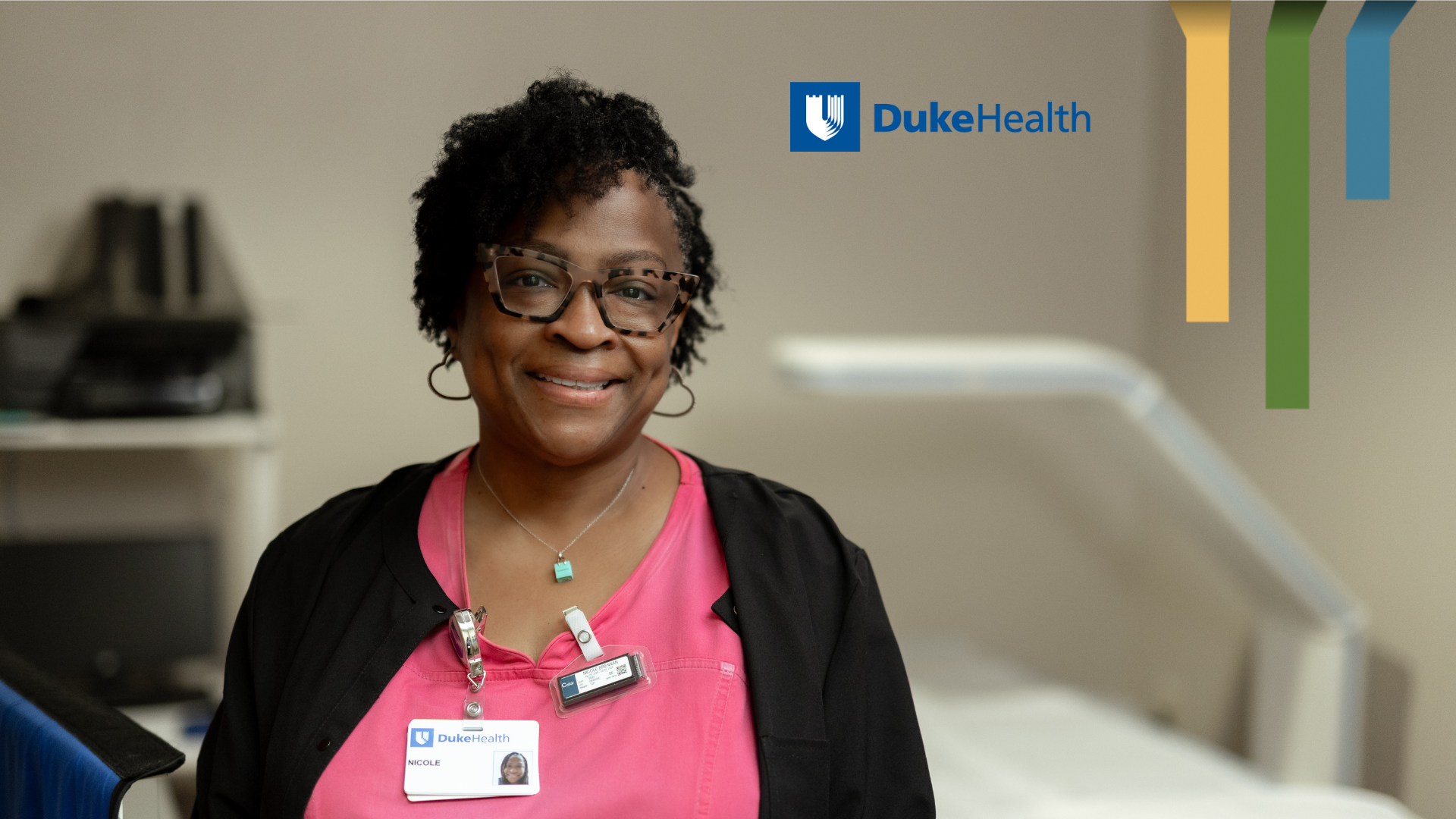 Female team member smiles in pink scrubs.
