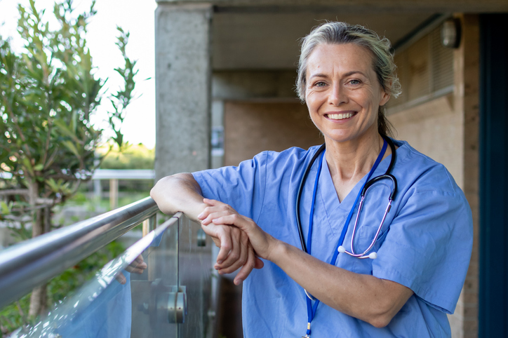 Nurse smiles in scrubs.