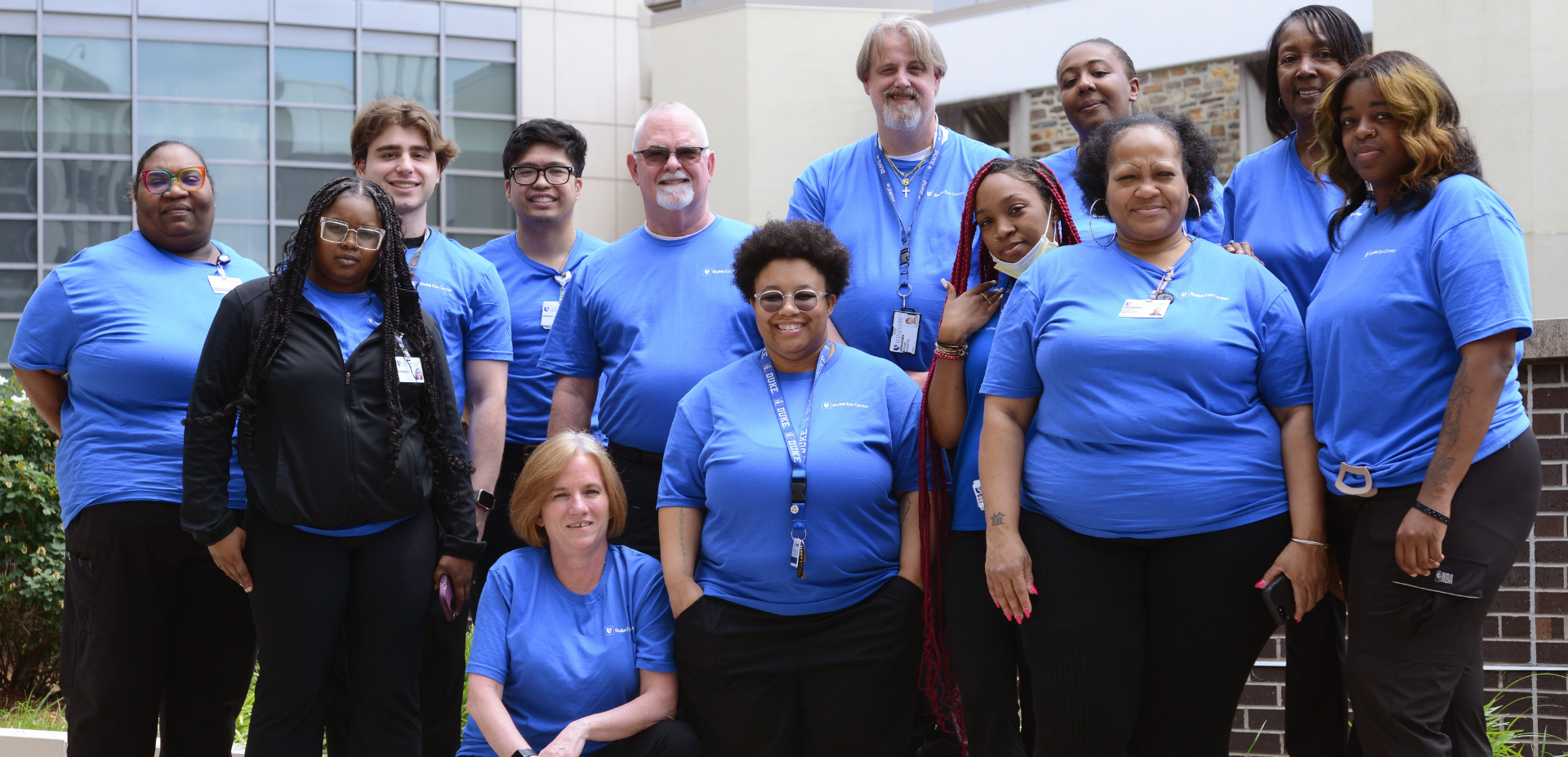 Team members smile in Duke blue shirts.