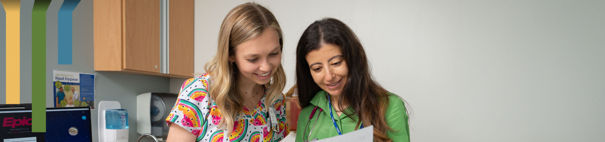 Two female team members look at a paper together.