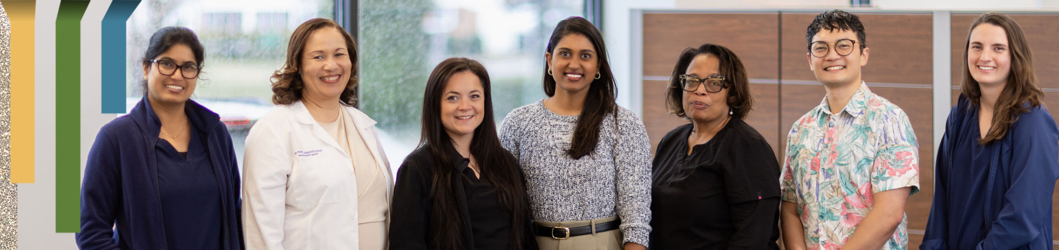A group of team members smiles together in a Duke Health office.