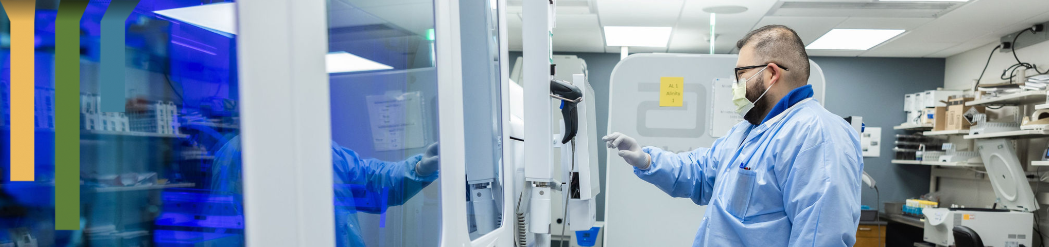 Male team member runs specimens through a lab machine.