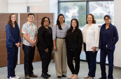 Group of team members smiles at an office.