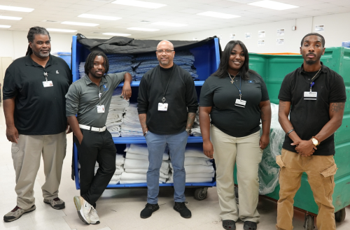 Supply Chain team members smile with linens.
