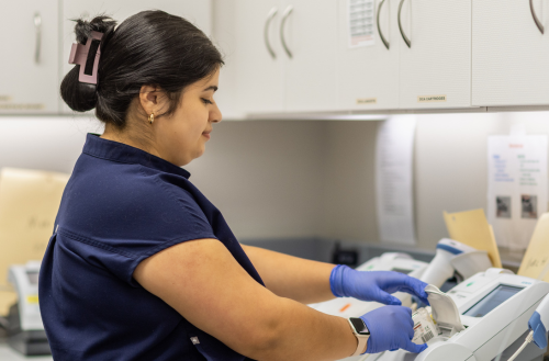 Lab team member runs a test on a machine.