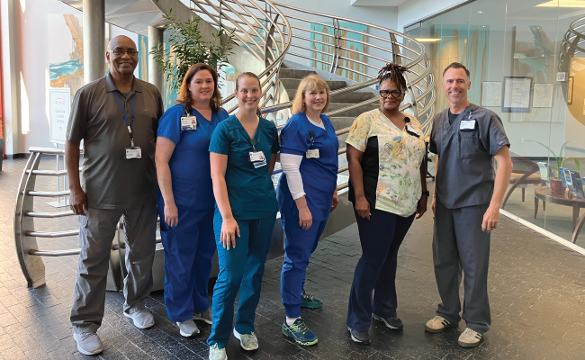 A group of team members smile together.