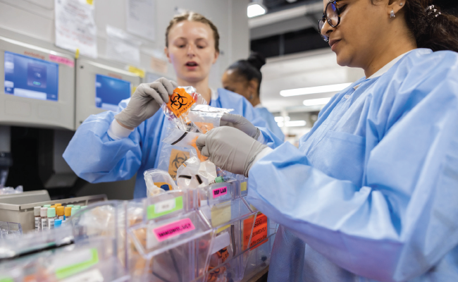 Two female lab team members work with samples.