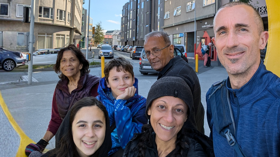 Team member and her family and parents smile together on a trip.