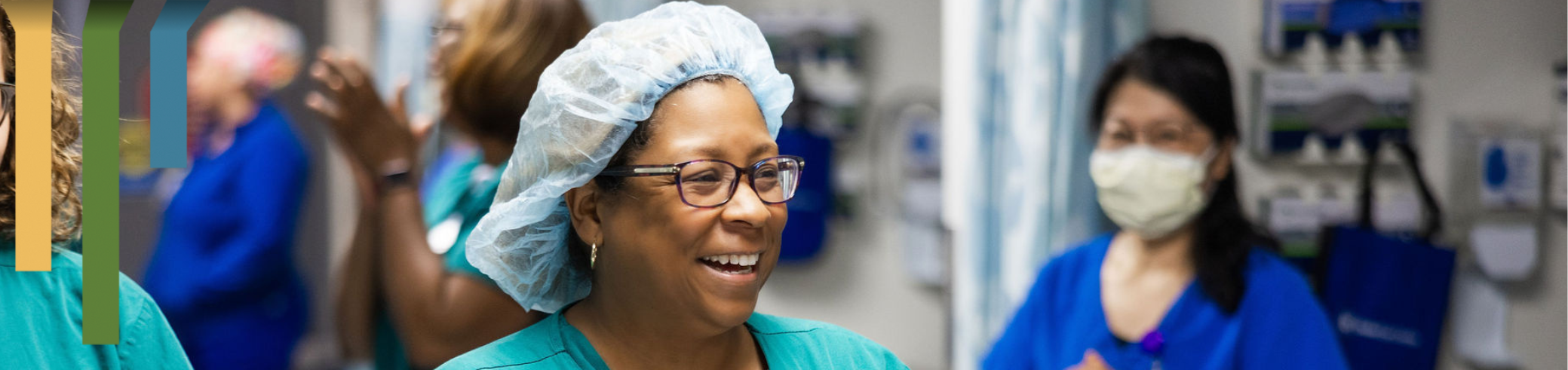 female team member smiling in a scrub cap.