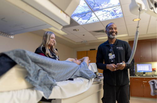 Male and female imaging team members assist a patient with a scan.