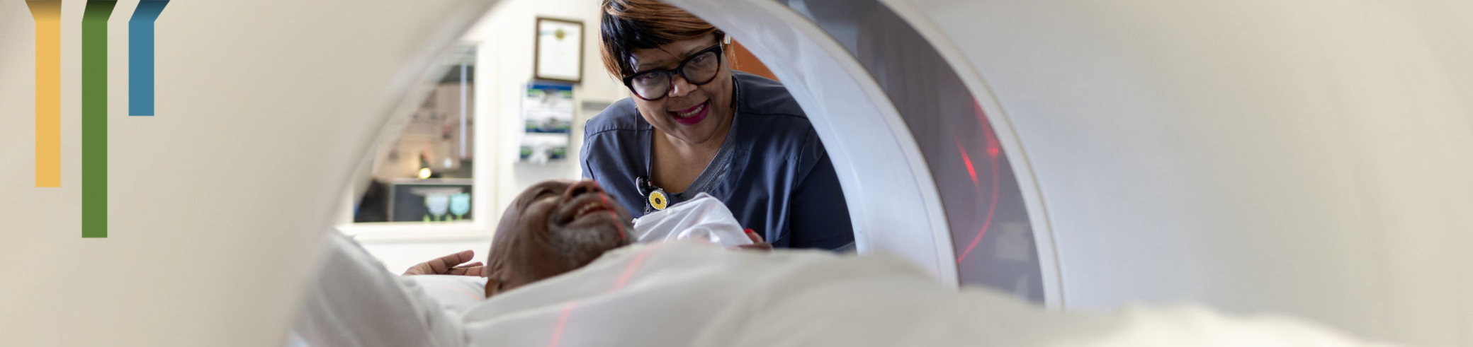 An imaging team members helps a patient during their MRI scan