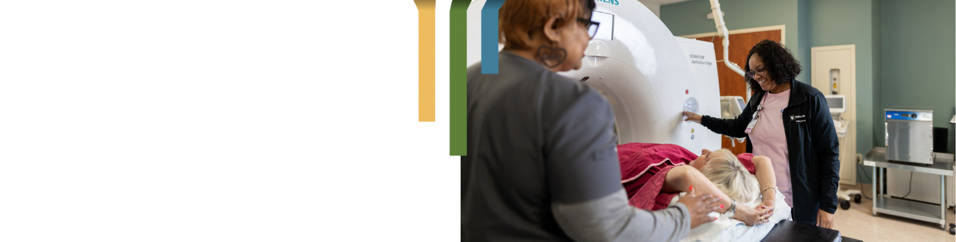 Two imaging team members help a patient get an MRI