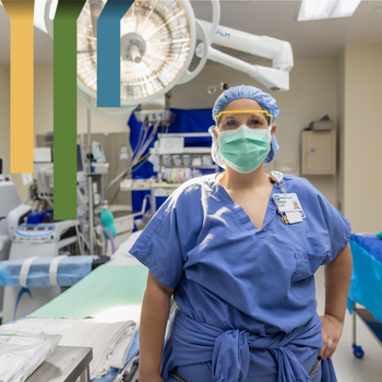 Female team member in blue scrubs smiles in an operating room.