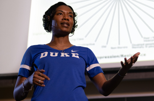 Women in Duke shirt speaks to a group.