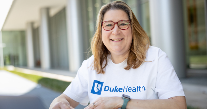 Team member studies on campus in a Duke Health shirt. 