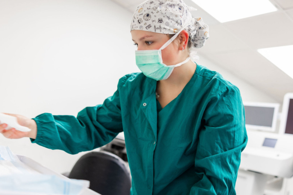 female nurse team member grabbing equipment in the operating room.