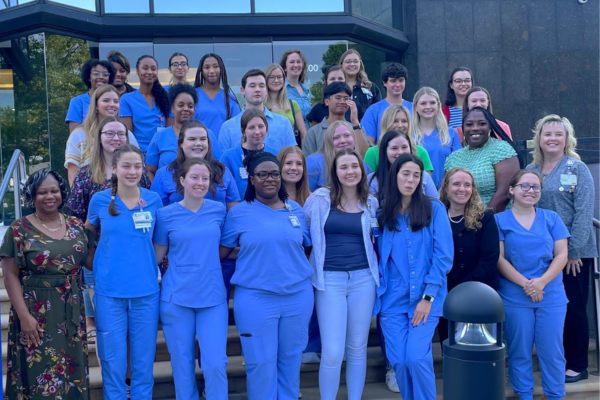 several professional nurse assistant program participants smile for a photo. 