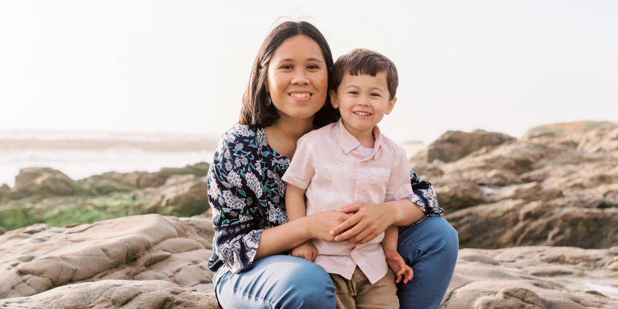 Rhodora hugs son on a rock smiling. 