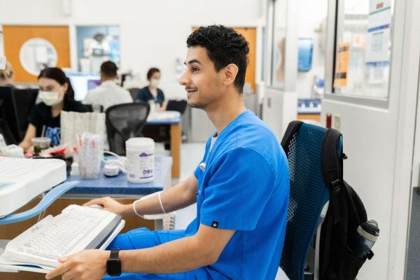 male nurse sitting at computer.