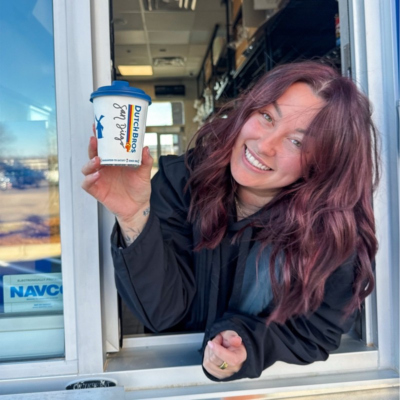 Brosita at the window smiling with cup