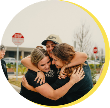 Broistas hugging outside a shop