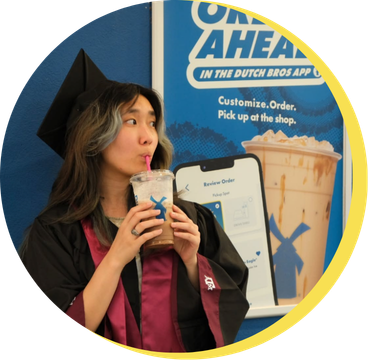 Girl in graduation cap next to a Dutch Bros sign