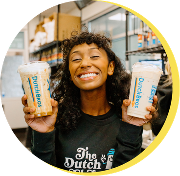 Shop member holding two Dutch Bros coffees 