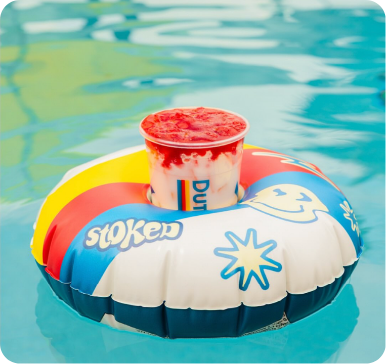 Dutch Bros drink floating in a floatie in a swimming pool