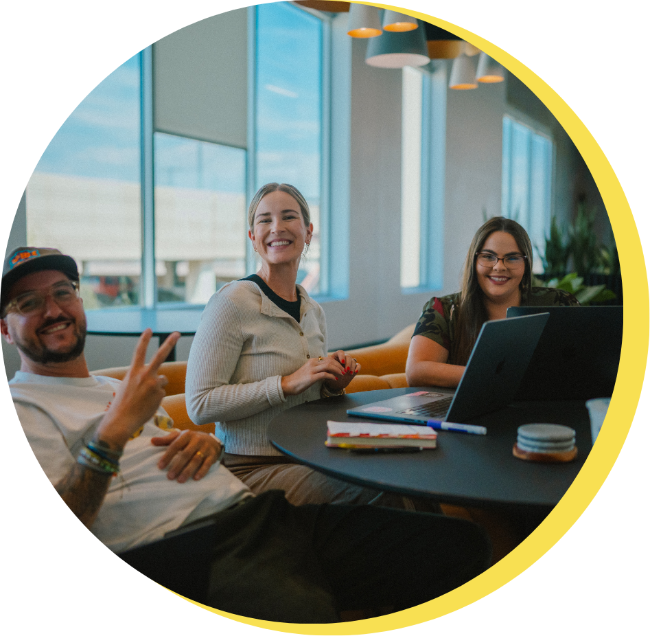 Three people smiling at the HQ office