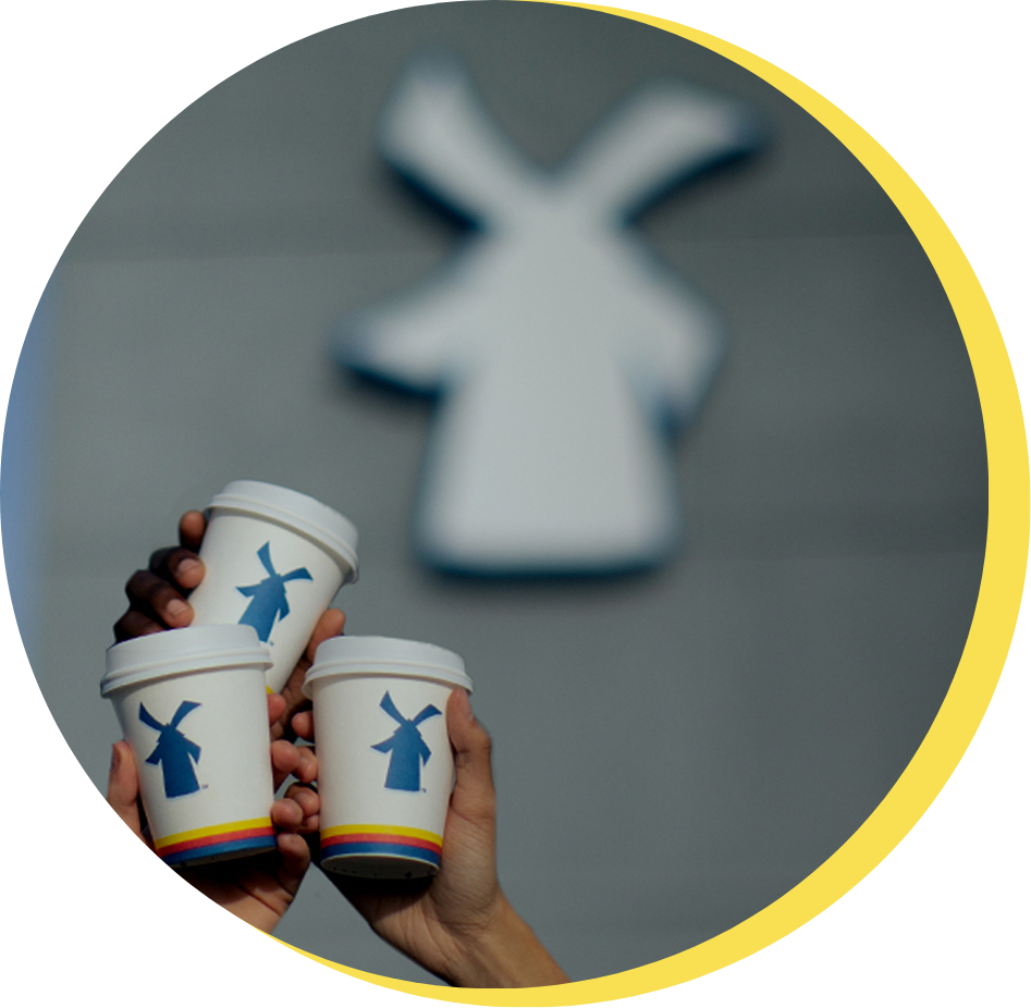 Three people holding up dutch cups next to our logo 