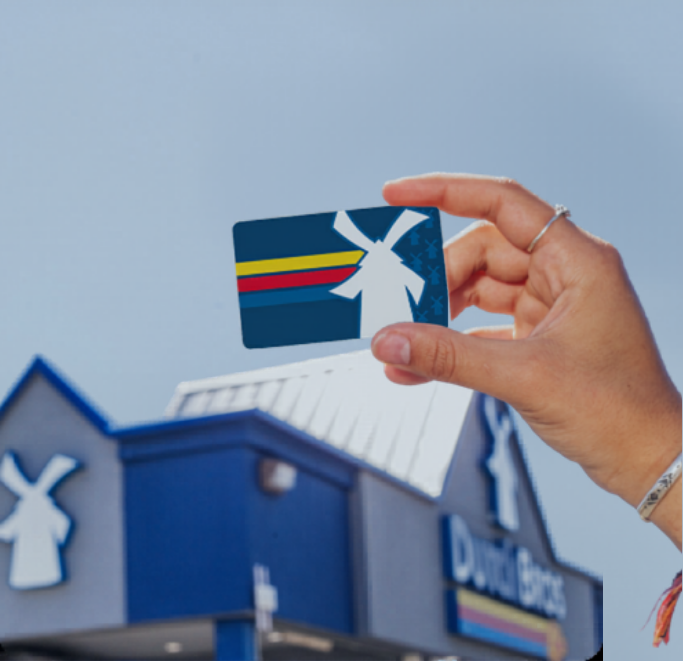 Someone holding a gift card above a shop