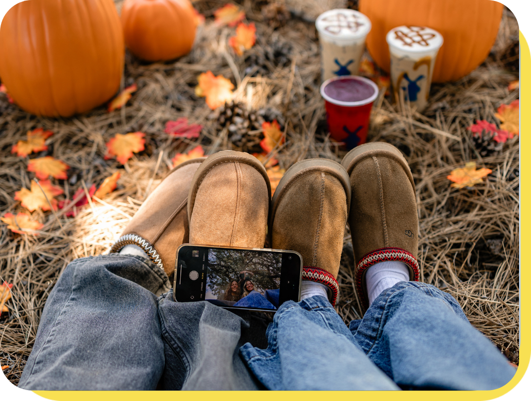 fall shoot with iphone on boots and two gals smiling in the camera