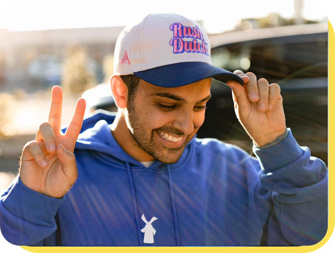 Person holding up peace sign with a rush dutch hat