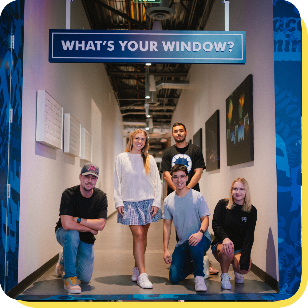 Employees standing under a sign that says "what's your window"